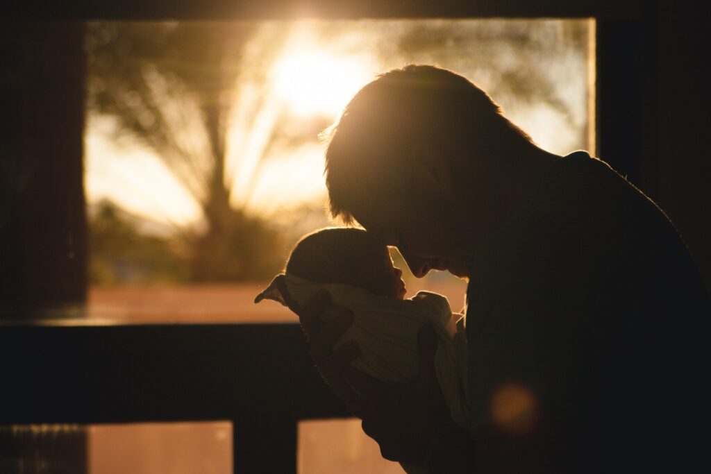 Vater mit Baby im Sonnenuntergang